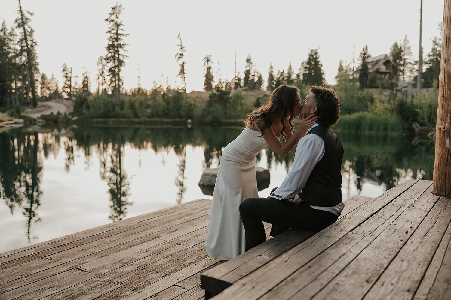A couple on the dock at golden hour, the lodge across the water.